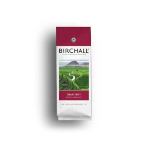 A bag of Birchall Great Rift Loose Tea with a vibrant red top showcases packaging ideal for a café atmosphere. It features an illustration of a lush green landscape, complete with a winding river and distant mountain, accompanied by the text: "A family tradition since 1872.