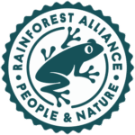The Café Rico Cafe Mundo Coffee Beans package displays an emblem, similar to a cozy café's logo, with a stylized frog at its center. Surrounded by the words "Rainforest Alliance" on top and "People & Nature" underneath, this seal highlights the dedication of all passionate baristas to sustainable practices.