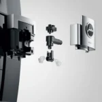 Close-up of a disassembled Jura GIGA X8 Pro Gen II Black Tanked Bean to Cup Coffee Machine, showcasing components such as a café-style faucet, connectors, and a branded panel. The plain background accentuates the precision and design favored by baristas.