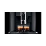 The Jura WE6 Tanked Bean to Cup Coffee Machine, with its elegant black design, is perfect for professional barista-quality espresso, brewing two café-style cups with a rich crema beautifully visible on both espresso shots.