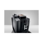 The Jura WE6 Tanked Bean to Cup Coffee Machine is a sophisticated and contemporary black coffee machine, evocative of a professional café ambiance. It includes a small display screen and two dispensers. The top is equipped with a compartment for coffee beans, allowing you to unleash your inner barista. The machine is showcased against a simple gray background.